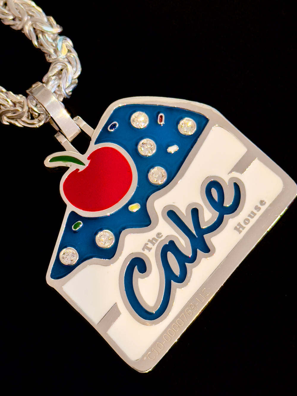 The Cake House pendant in white, blue and red enamel with set stones, on a silver rope chain