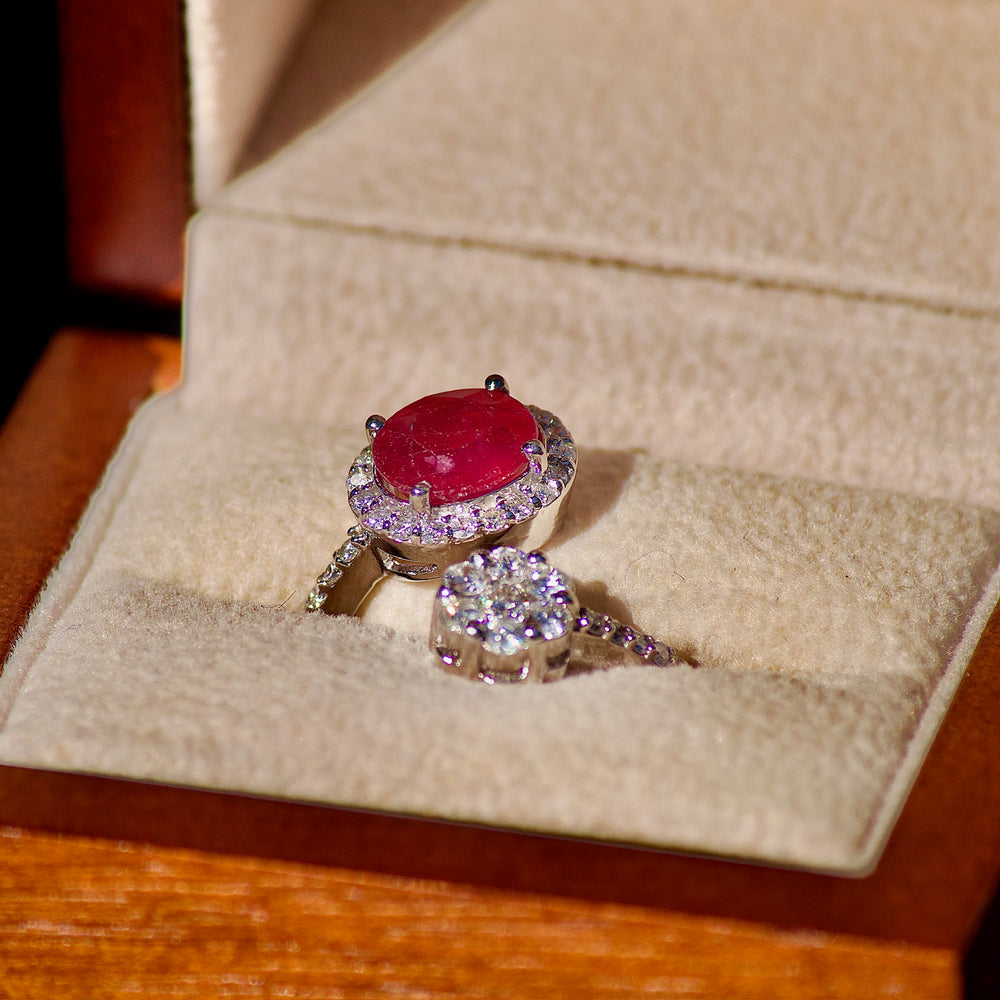 Round silver pendant with a raised signature on a hammered face