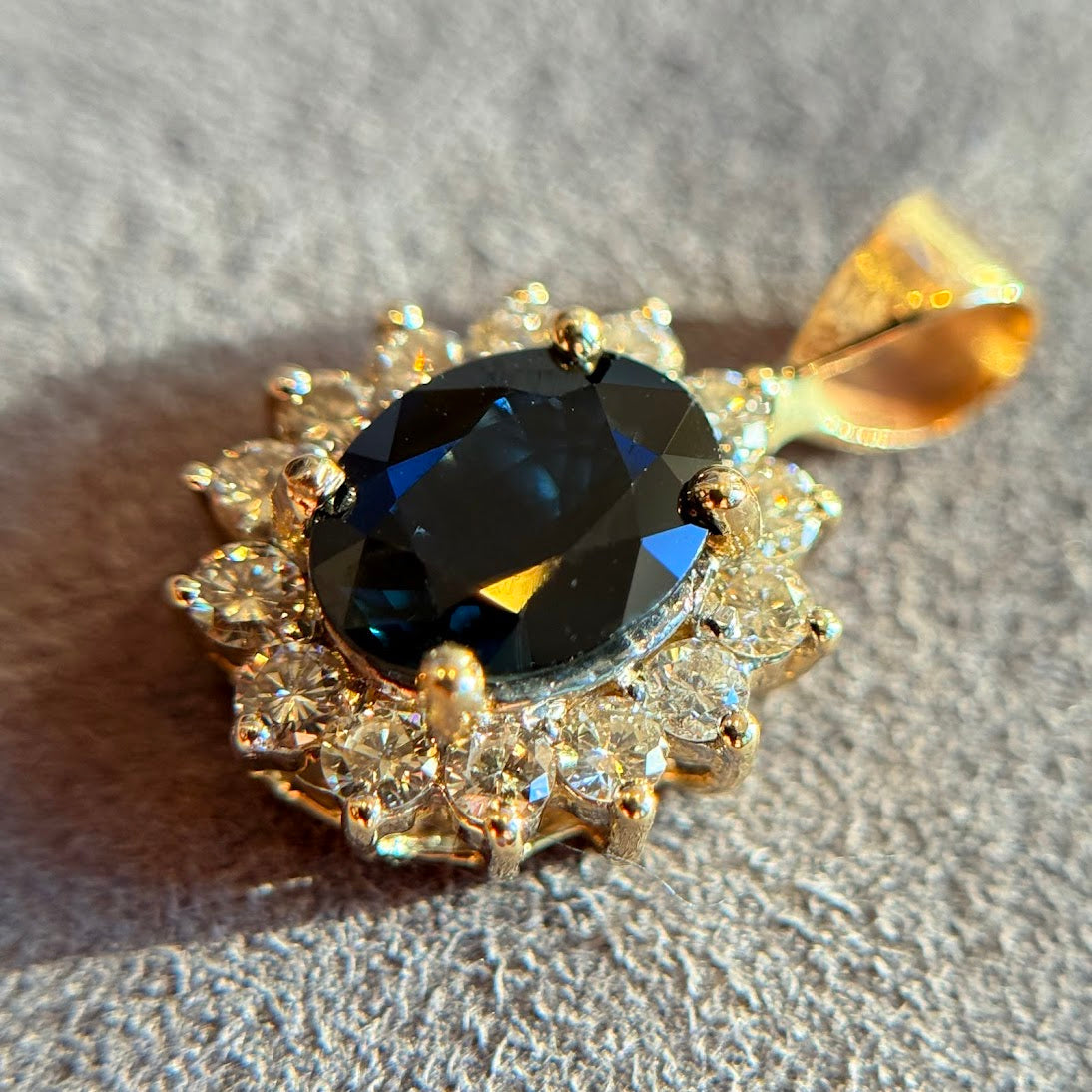 Sapphire pendant with a white stone halo in yellow gold