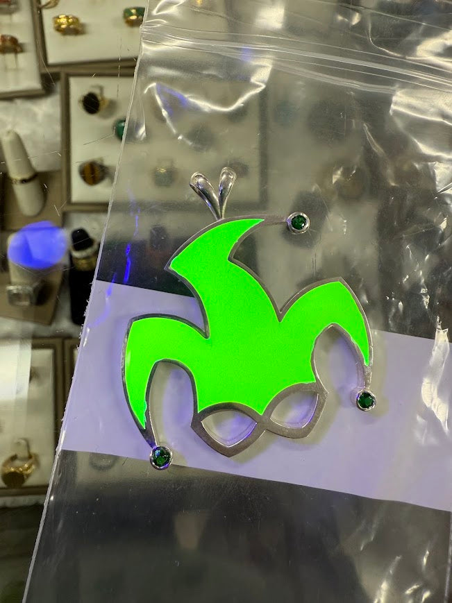 The same jester pendant glowing green in the dark