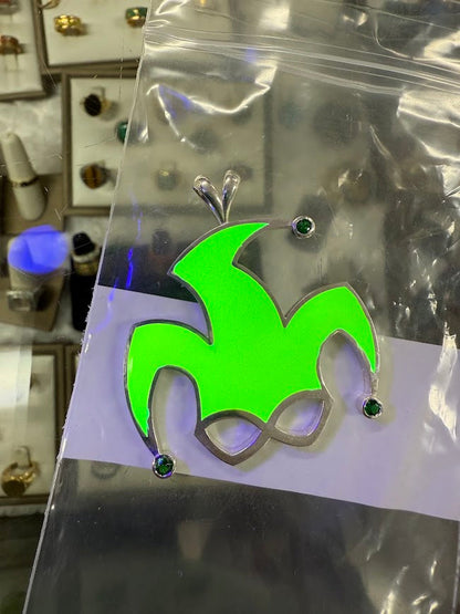 The same jester pendant glowing green in the dark
